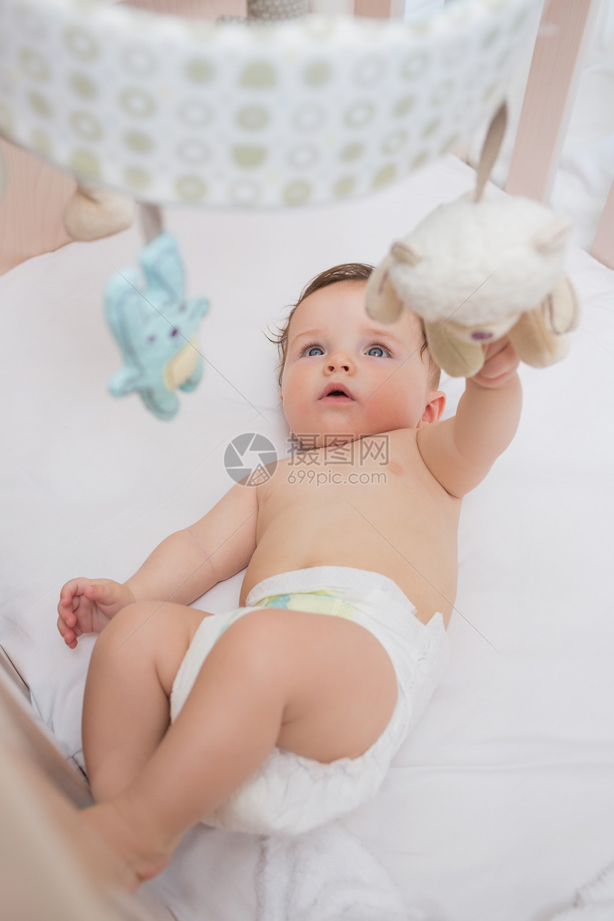 在婴儿床玩玩具的可爱婴儿图片