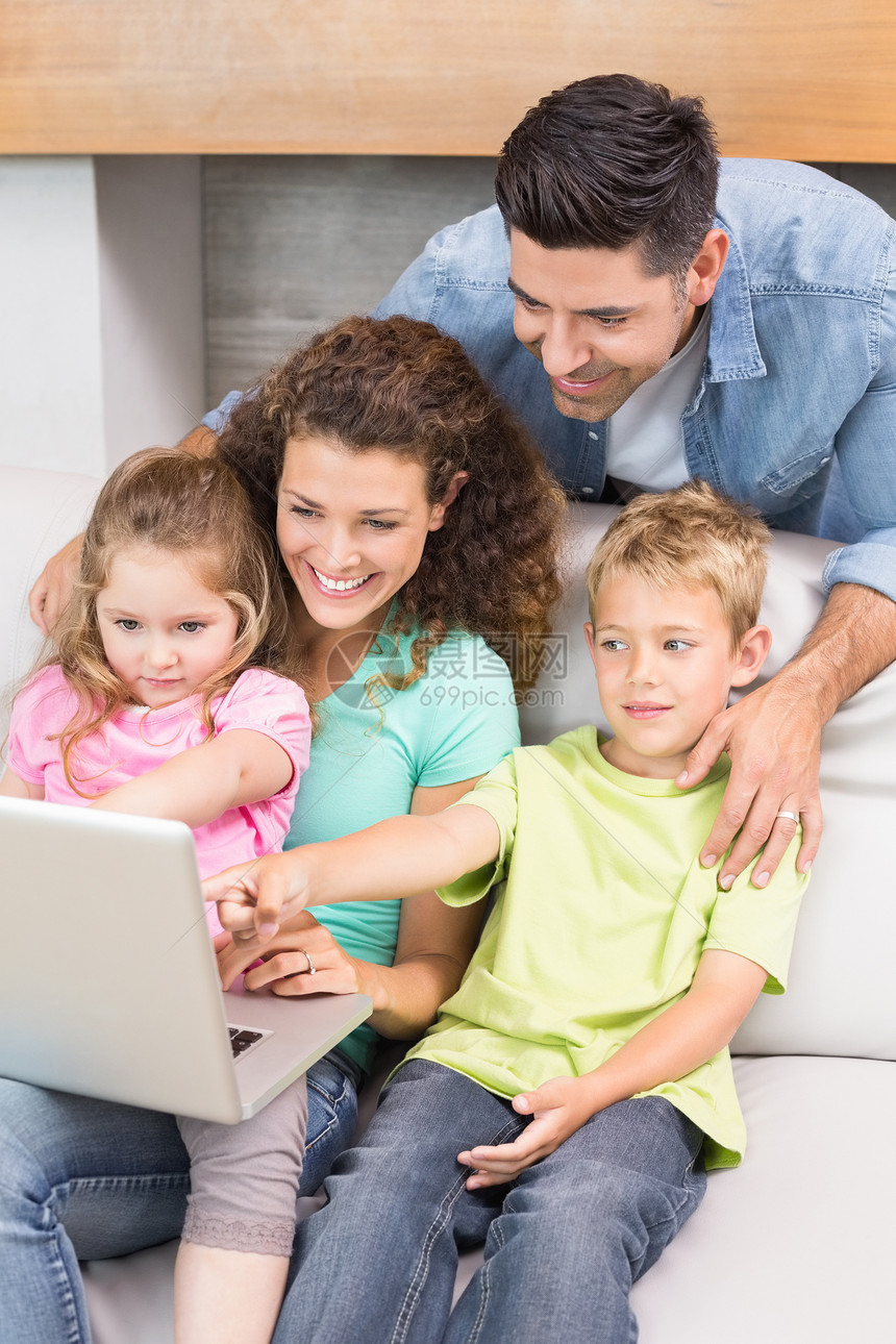 坐在沙发上欢乐的家庭看着笔记本电脑图片