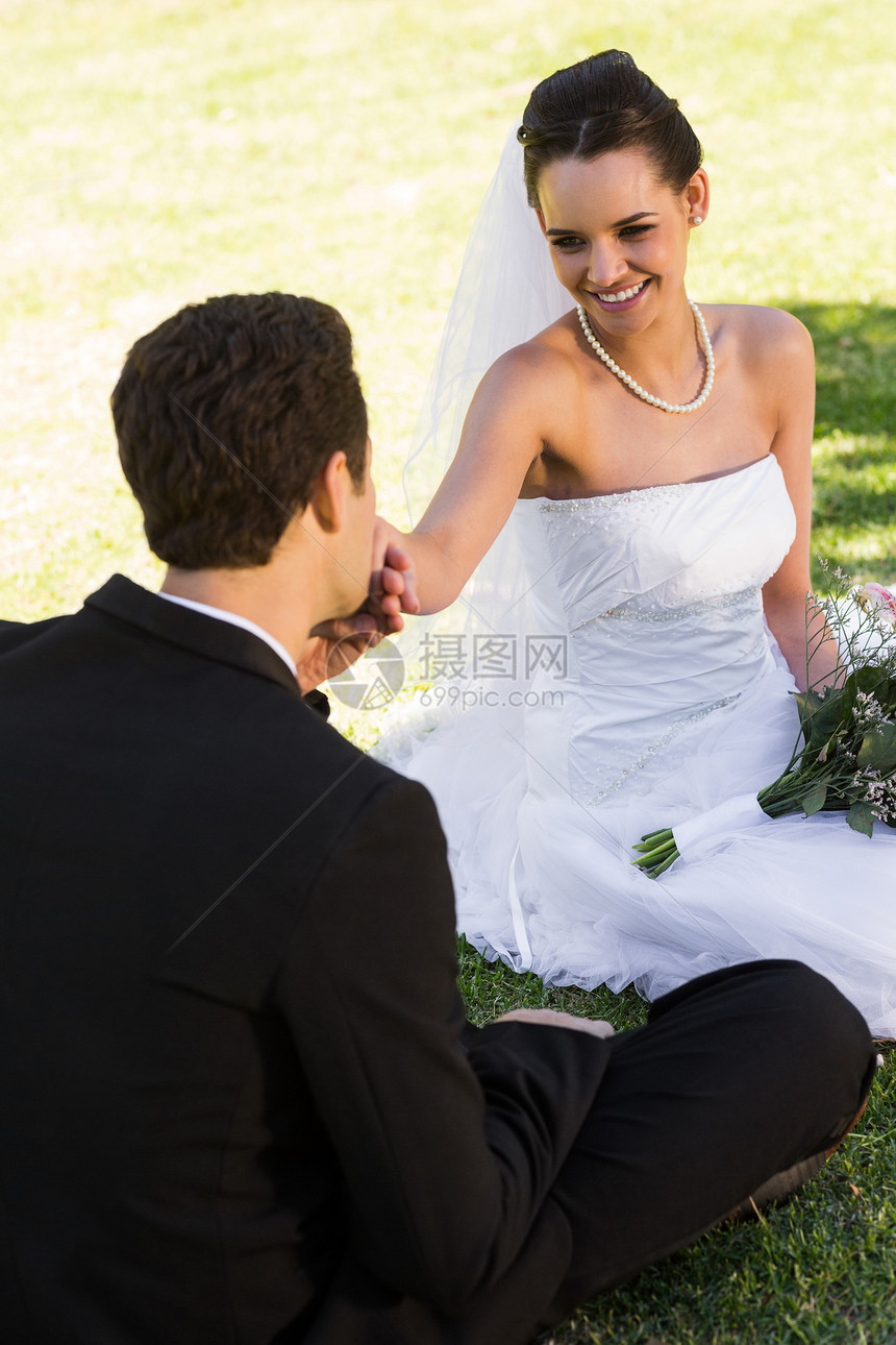 格隆在公园亲吻他美丽的新娘的手图片