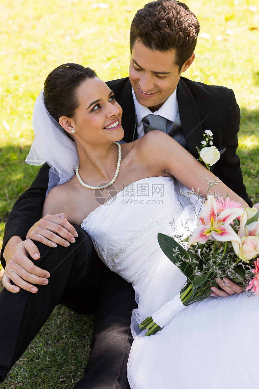 坐在公园里的幸福新婚夫妇婚姻花束婚礼女性妻子已婚男人裙子夫妻团结图片