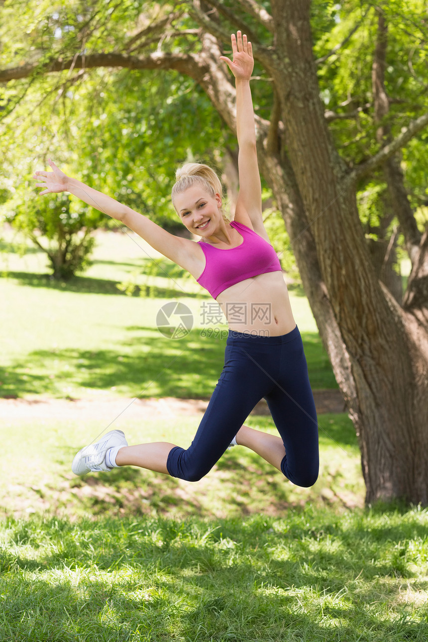 参加公园运动服装跳跃的全年妇女图片