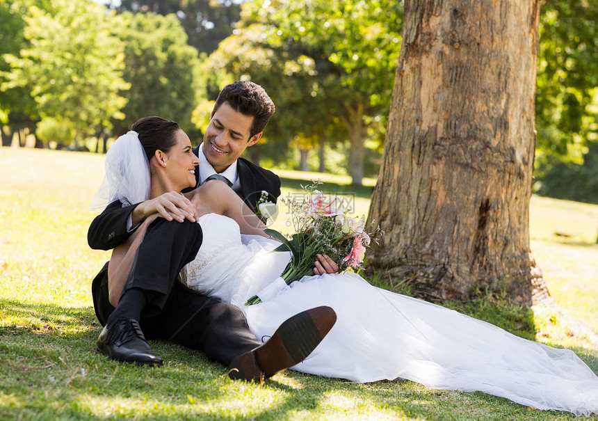 快乐的新婚夫妇在公园放松图片