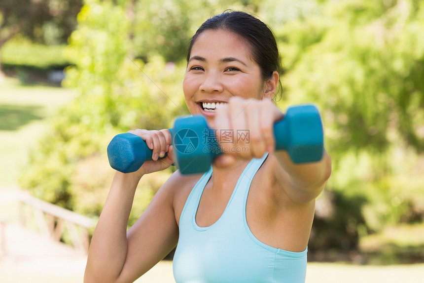 健康 微笑的女士在公园里与哑铃一起运动生活方式身体调子女性活动锻炼蓝色闲暇文胸护理图片