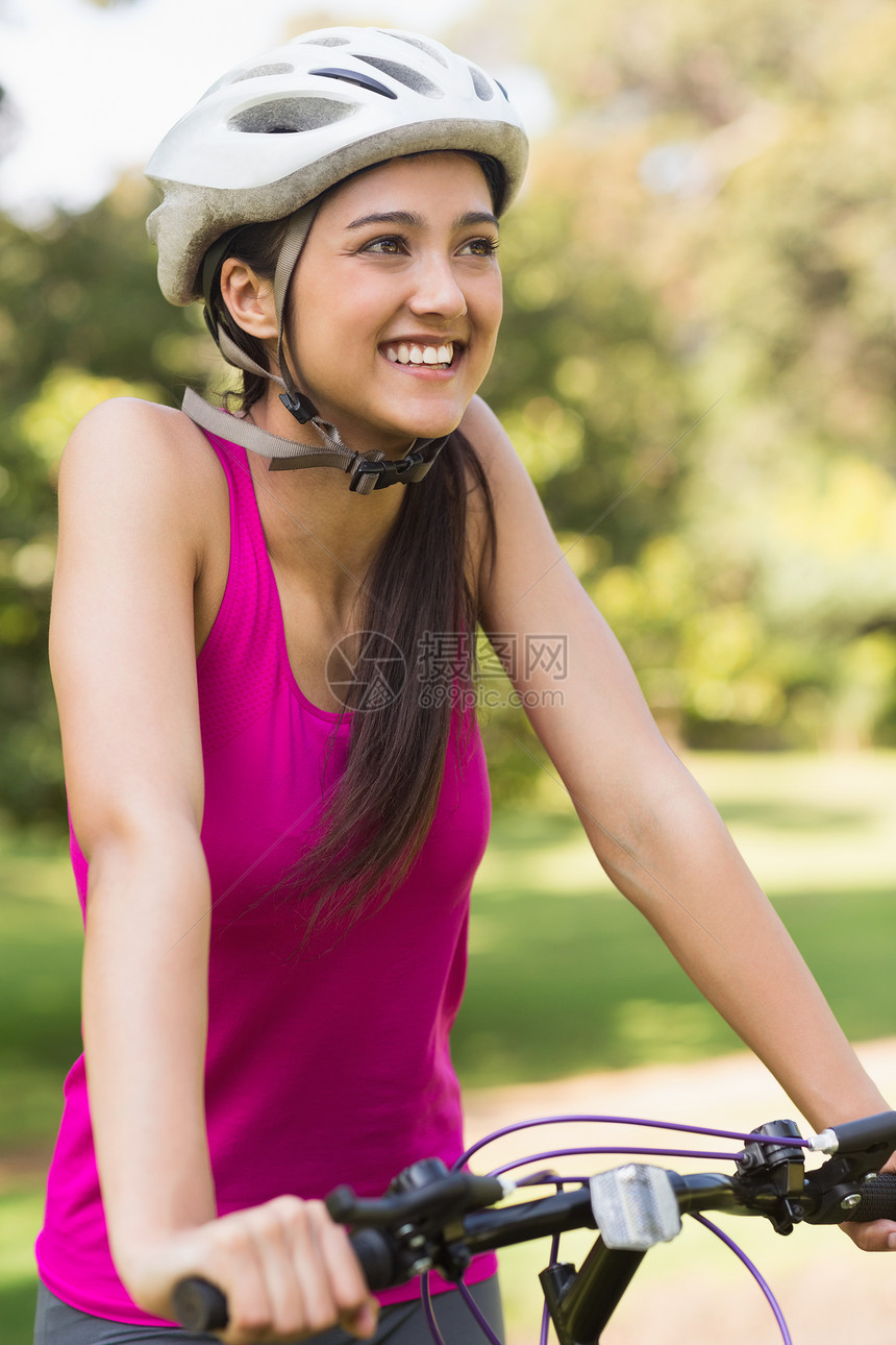 配戴头盔在公园骑自行车的妇女快乐闲暇运动混血锻炼背心身体生活方式活动体力图片
