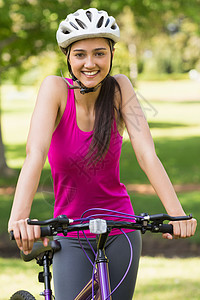 配戴头盔骑自行车的年轻女子背景图片