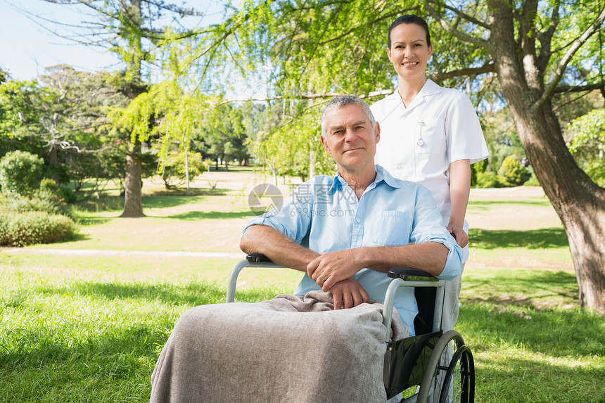女人与她父亲坐在轮椅上 在公园功能退休男人截瘫成人男性病人残疾人闲暇疾病图片