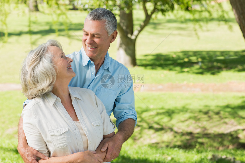 在公园的爱和快乐的成熟情侣草地晴天人员头发夫妻双臂女士退休闲暇绿色图片
