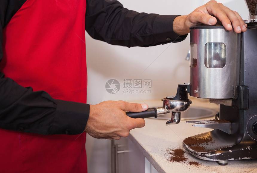 利用咖啡研磨机研磨咖啡豆的酒吧图片