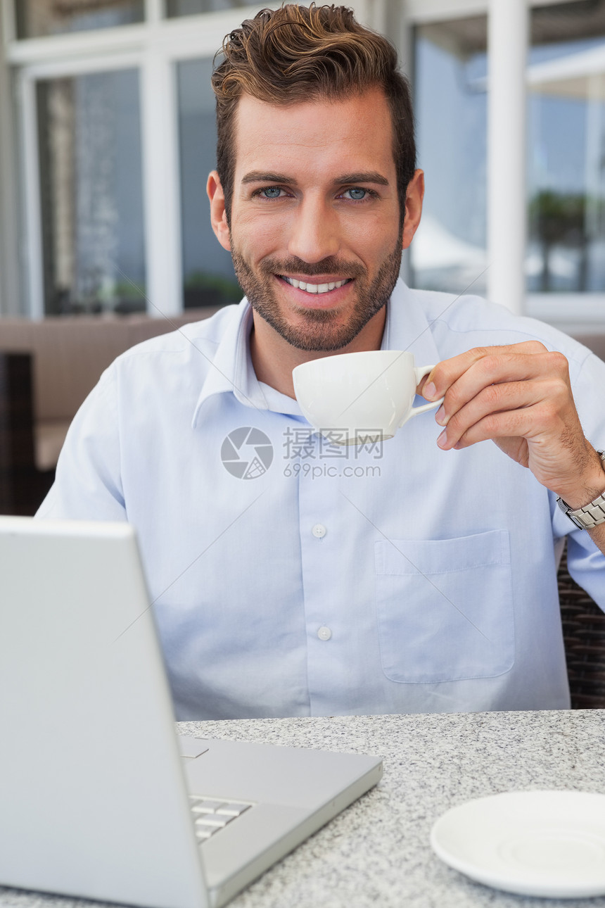 手持笔记本型饮用水咖啡的笑脸商务人士图片