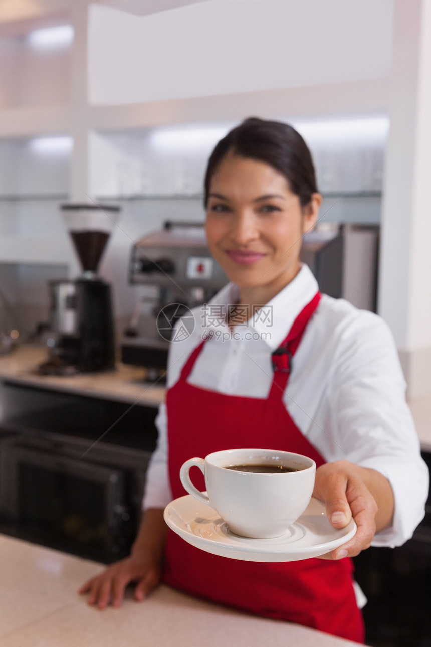 漂亮的咖啡厅 在相机上笑着的咖啡杯围裙职员微笑咖啡店女士饮料餐厅咖啡机工作职业图片