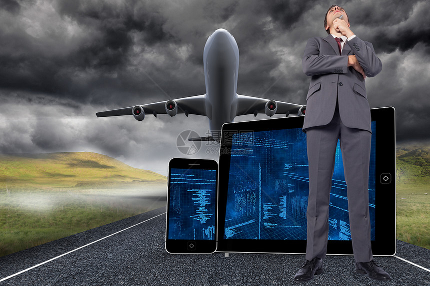 深思熟虑的商务人士用笔握着下巴的综合形象商业假期棕色飞机科技旅行电脑街道着陆风暴图片