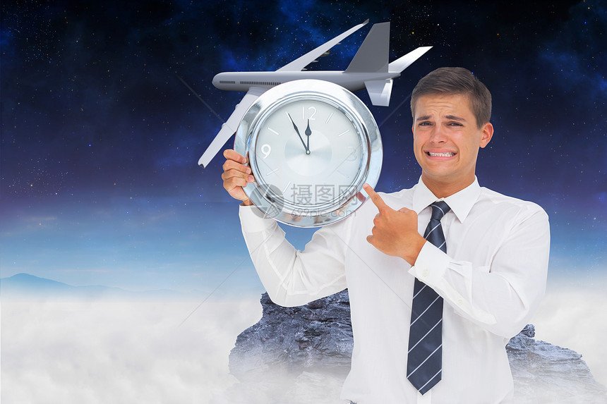 焦虑的商务人士持有和显示一个时钟的复合图像飞机绘图商务起重衬衫航空天空领带男性航班图片