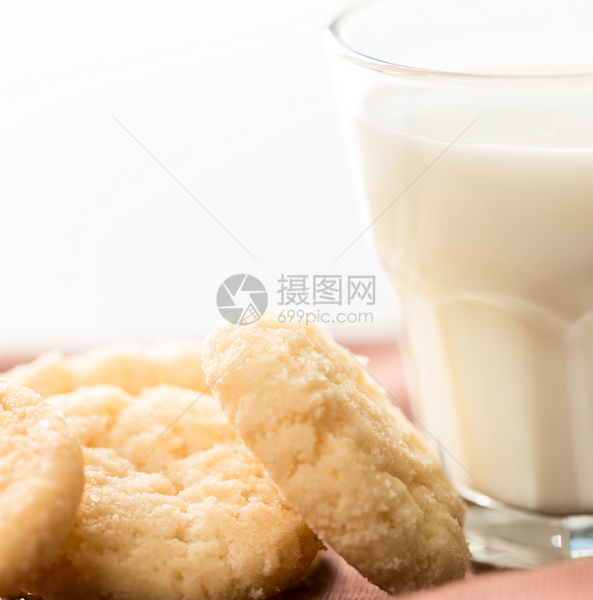 饼干和杯子里的牛奶 在餐巾纸上特写图片