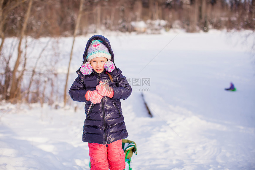 小可爱的快乐女孩 享受阳光明媚的冬日雪衣服孩子童年草地雪花季节外套公园婴儿微笑图片