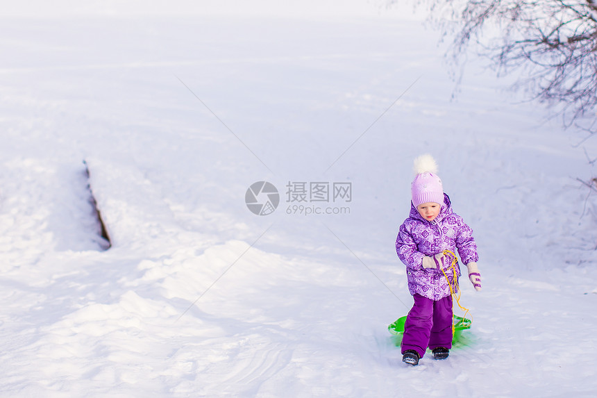 小女孩在温暖的冬日拉起雪橇草地衣服雪花公园喜悦森林幸福季节童年女孩图片