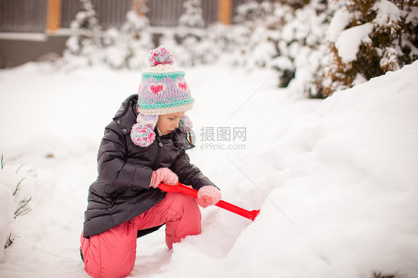 可爱的小女孩玩雪铲雪 在冬日打滚森林晴天婴儿幸福微笑手套季节快乐女性童年图片