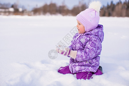 雪与小女孩快乐的小女孩在寒冬阳光明日玩雪薄片天气幸福童年闲暇活动女儿雪花降雪婴儿背景