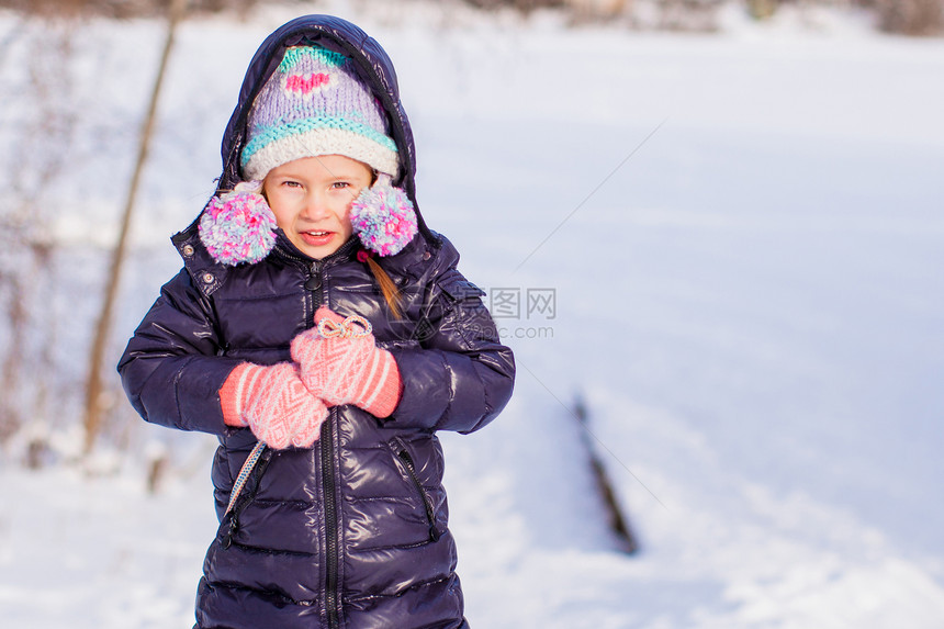 小可爱的快乐女孩 享受阳光明媚的冬日雪帽子微笑草地雪花乐趣外套季节公园孩子女儿图片
