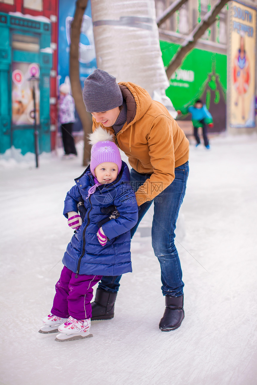 和年轻父亲在一起的快乐小女孩 在滑冰场玩得开心手套男性生活方式娱乐爸爸婴儿女儿数字小姑娘男人图片
