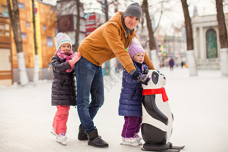熊猫滑冰有年轻父亲的小女孩 喜欢滑冰乐趣训练爸爸数字学习男性溜冰者教学女孩闲暇背景