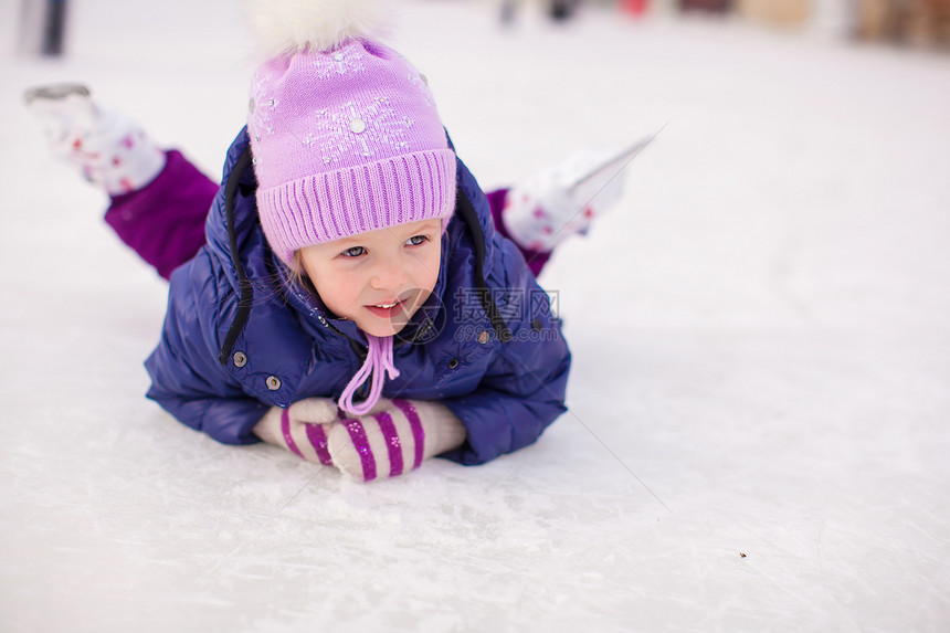 秋天后 可爱的小女孩坐在冰上 穿着溜冰鞋坐着冰雪运动童年手套训练乐趣速度小姑娘喜悦滑冰场爱好图片