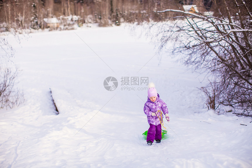 小女孩在温暖的冬日拉起雪橇快乐森林幸福公园雪花帽子季节童年衣服乐趣图片