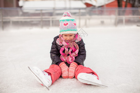 秋天后坐在滑冰溜冰场上的小可怜女孩女儿手套学习女性教学爱好帮助闲暇溜冰者舞蹈背景图片