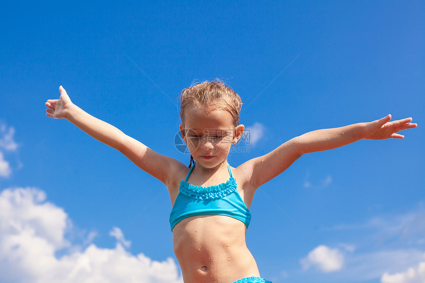 可爱的小女孩 在蓝天上张开双臂背景女性喜悦青年微笑女儿泳装游泳者娱乐假期童年图片