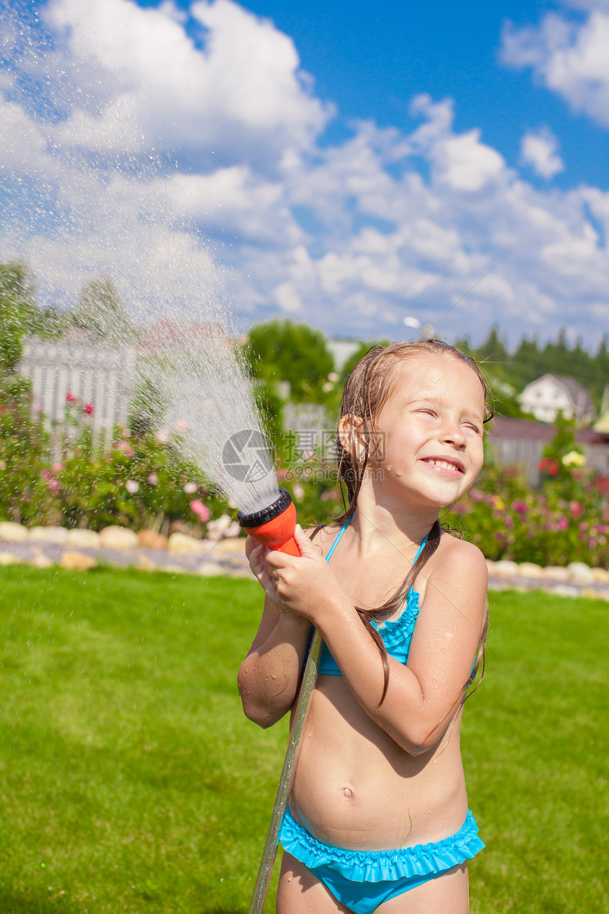 快乐可爱的小女孩 从水管里倒水 笑着运动乐趣女孩花园孩子闲暇灌溉液体喜悦飞溅图片