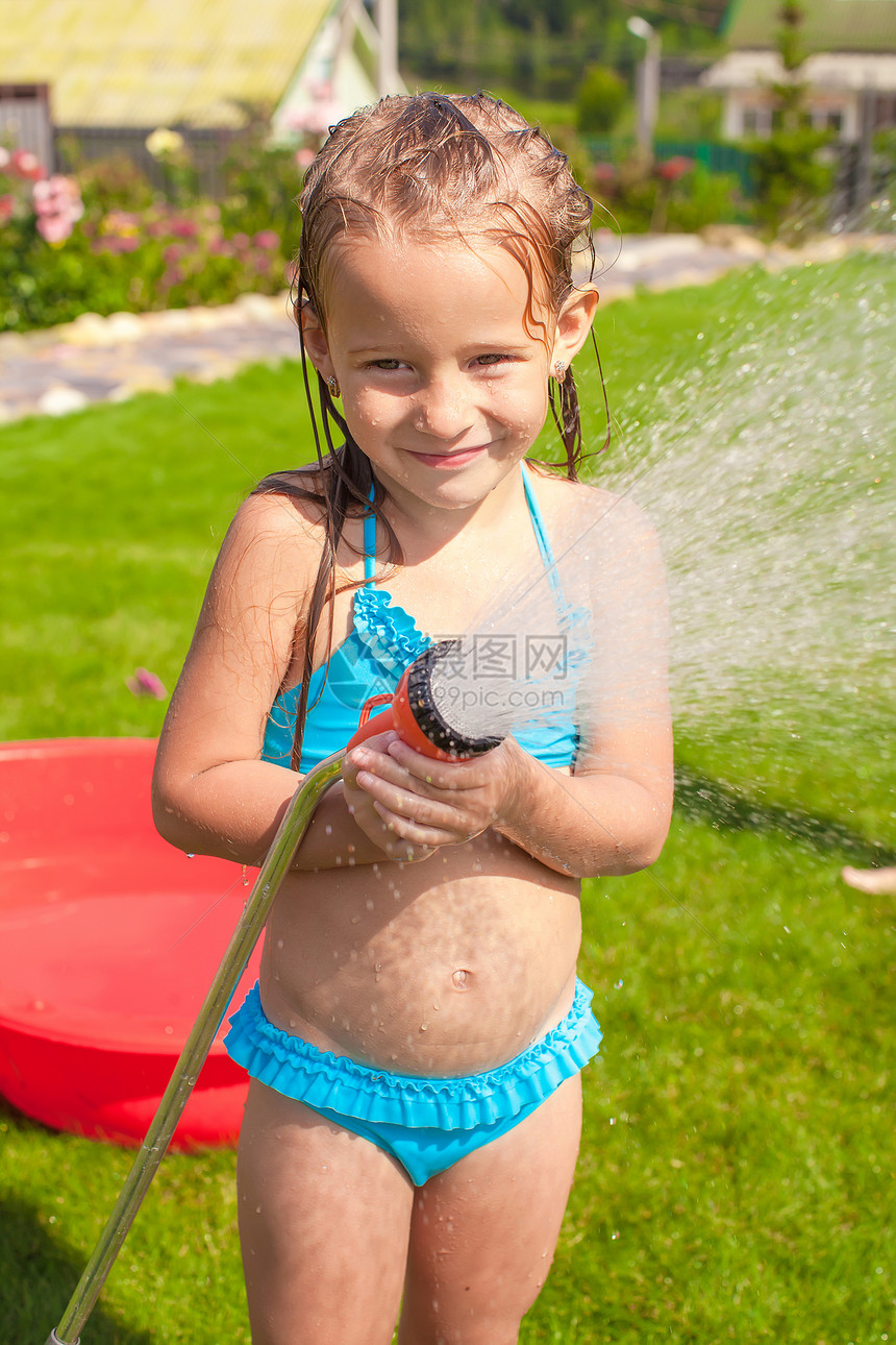 快乐的小女孩从水管里倒水 然后大笑图片
