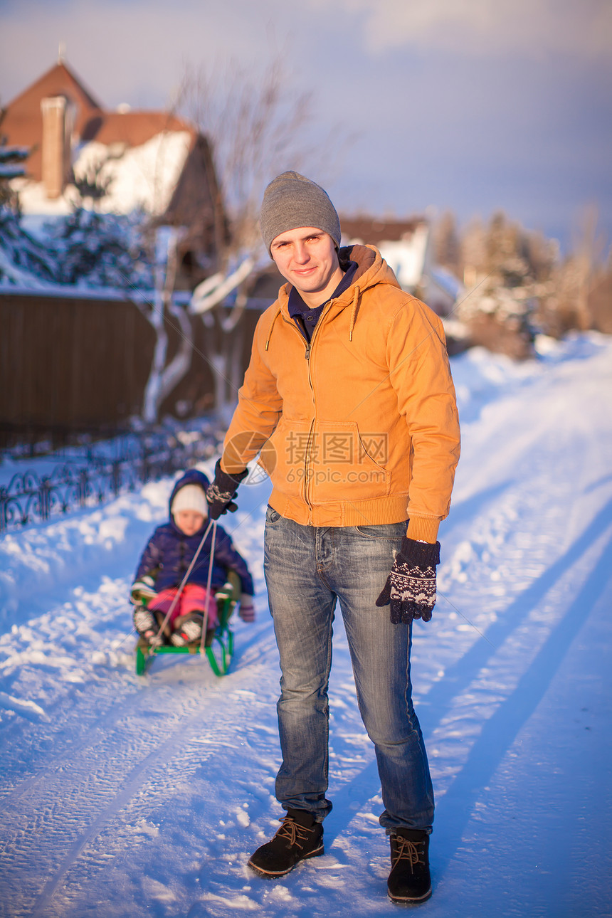 年幼的爸爸和小女孩 在寒冷的冬季天去滑雪父母晴天童年成人快乐孩子季节女儿乐趣男人图片