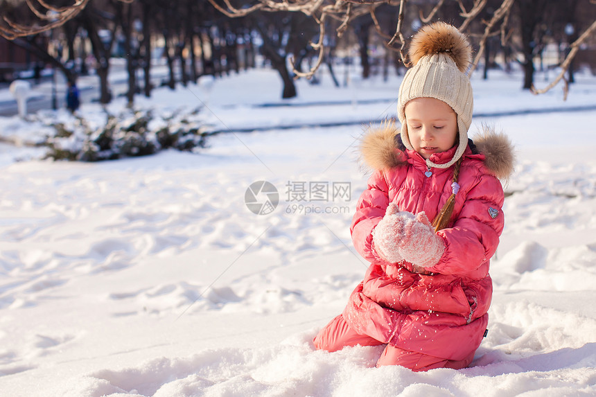 可爱的小女孩 在寒冬天户外玩得开心孩子乐趣雪堆闲暇快乐公园女性幸福雪花手套图片