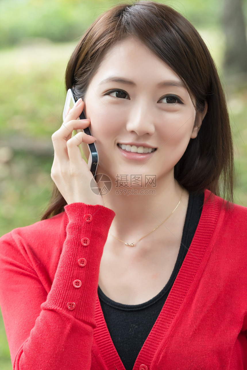 微笑的亚洲年轻女子打电话魅力女性技术乐趣女士手机图片