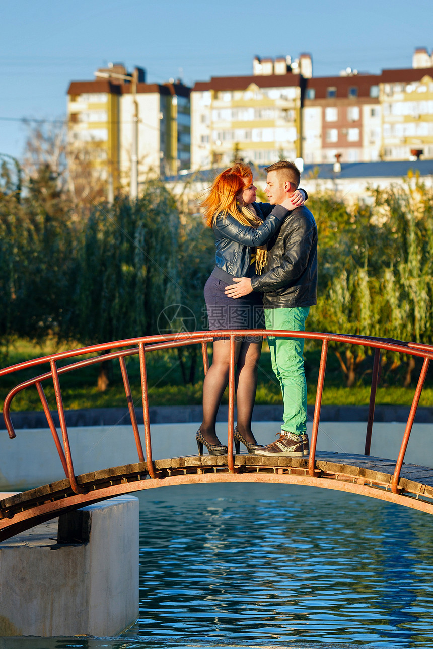 一对在桥上拥抱的情侣夫妻亲热公园天气男人牛仔裤家庭闲暇男性池塘图片