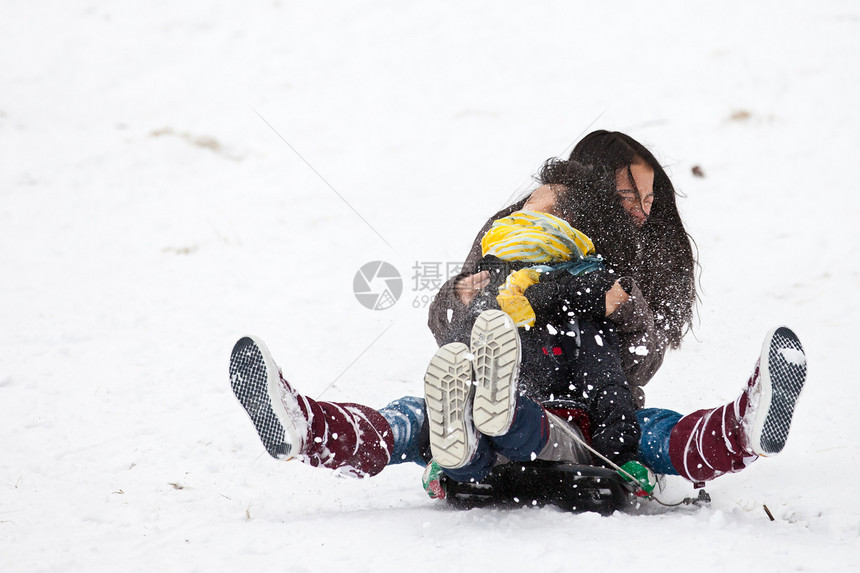 两个姊妹骑雪橇 紧紧抱在一起照顾活力情感女孩姐姐运动速度闲暇孩子们下坡图片