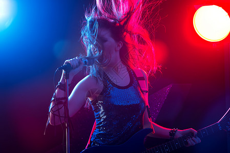 摇滚明星在舞台上唱歌女士音乐家呐喊女性青少年流行音乐会活动吉他文化流行音乐背景图片