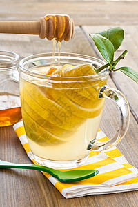 用新鲜柠檬做的茶勺子条纹疗法玻璃维生素蜂蜜滴水餐巾乡村茶杯背景图片