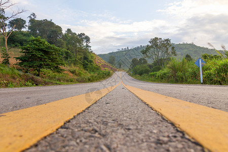 山上的道路场地黄土地绿色街道树叶森林运输天空旅行季节背景图片