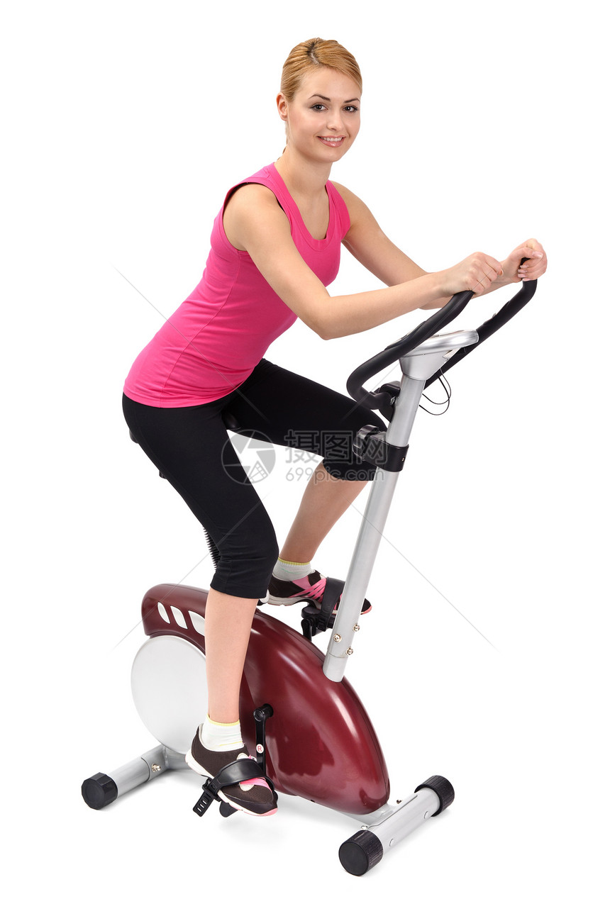 年轻妇女在室内骑自行车锻炼行车纺纱健身微笑有氧运动女性脂肪器材训练女孩图片