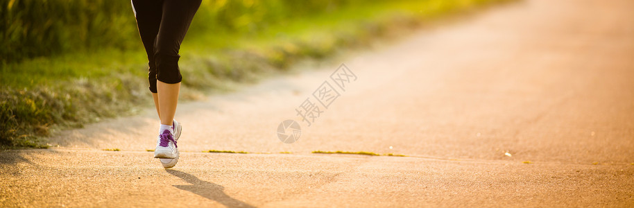 在路上的女人一名女性选手在路上的腿树木城市赛跑者成人运动装活力运动慢跑者女孩娱乐背景