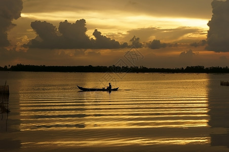 汛期日出时在河上坐划船的人背景