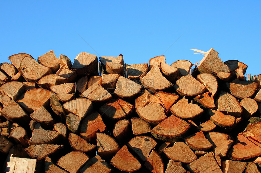 堆叠的原木蓝色木材木桩木头木柴震惊树干木屑木板天空图片