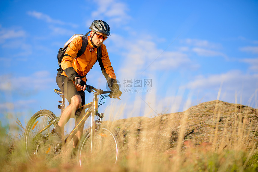 在美丽的山道上骑自行车的赛车女运动员运动骑士踪迹成人速度头盔天空男性车轮娱乐图片