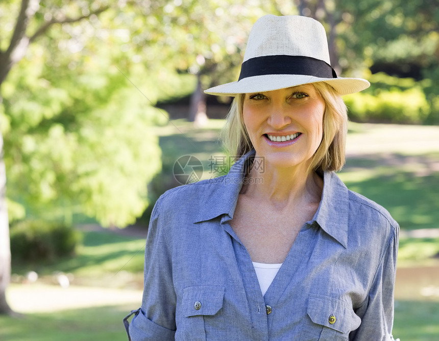 在公园的快乐女人时间闲暇女性便服休假农村空闲绿地微笑太阳帽图片
