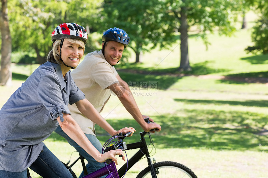 夫妇在公园骑自行车微笑图片
