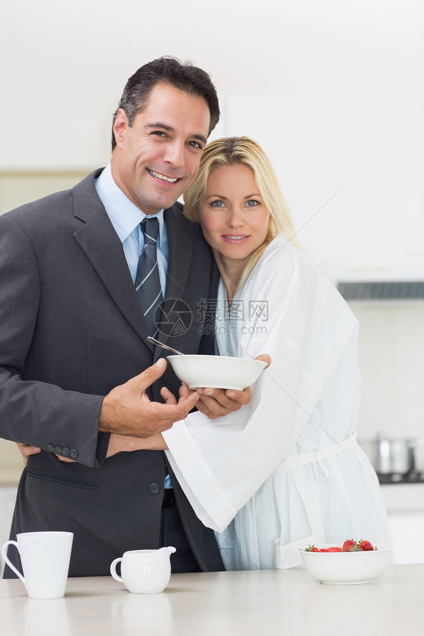 一个女人的肖像 在厨房里拥抱着穿好衣服的男人图片