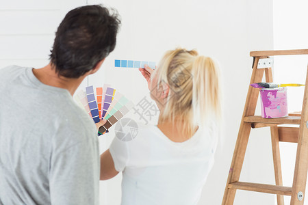 一对夫妇选择房间绘画颜色的近视图背景图片