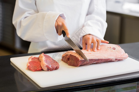 在厨房里切肉的手部中食物职业柜台烹饪厨师菜板准备餐厅工作背景图片