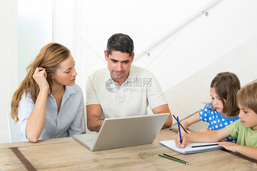 父母在孩子染色时使用笔记本电脑图片