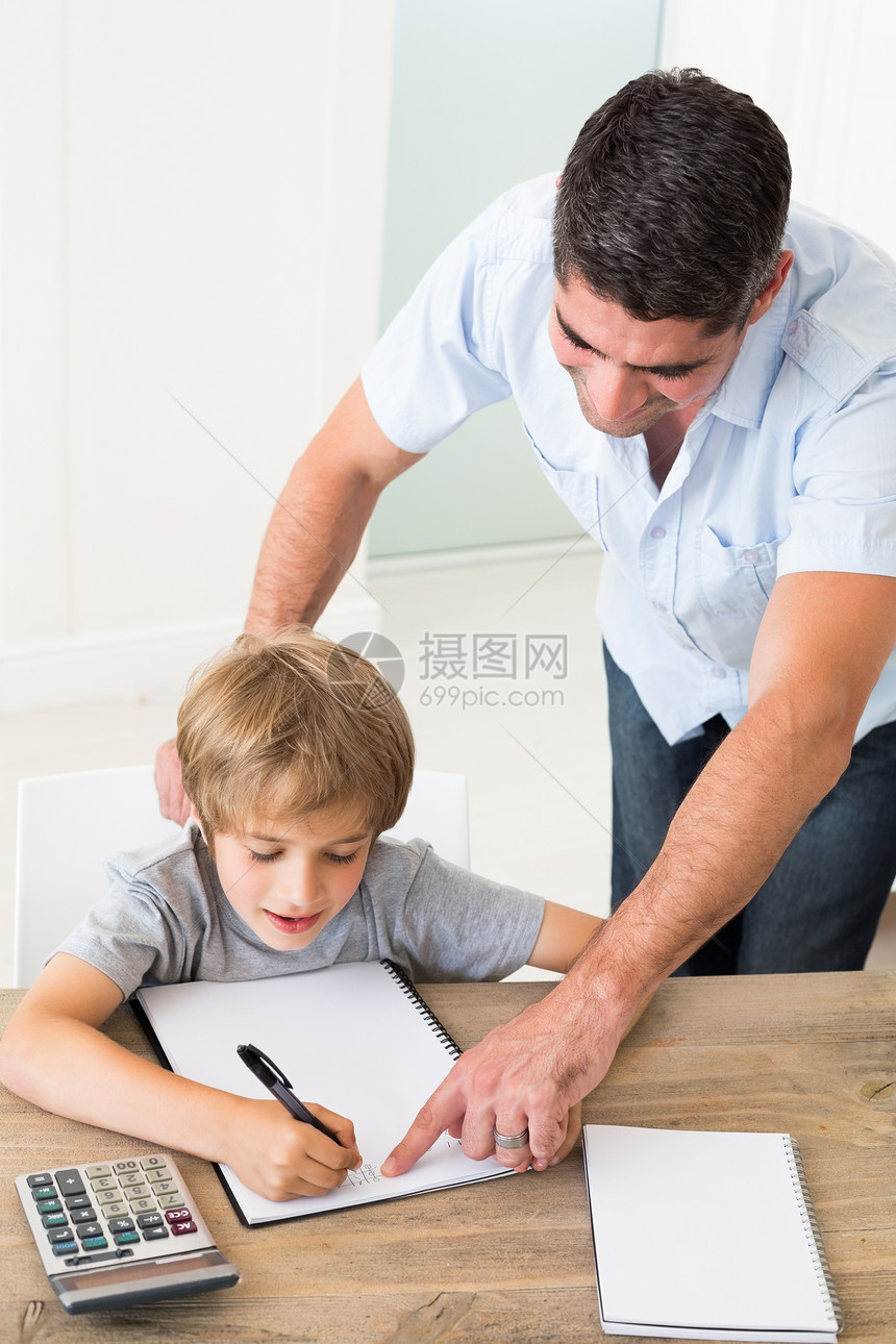 父亲帮助男孩解决数学问题便服家庭作业教育家居男生笔记本写作男人孩子房子图片